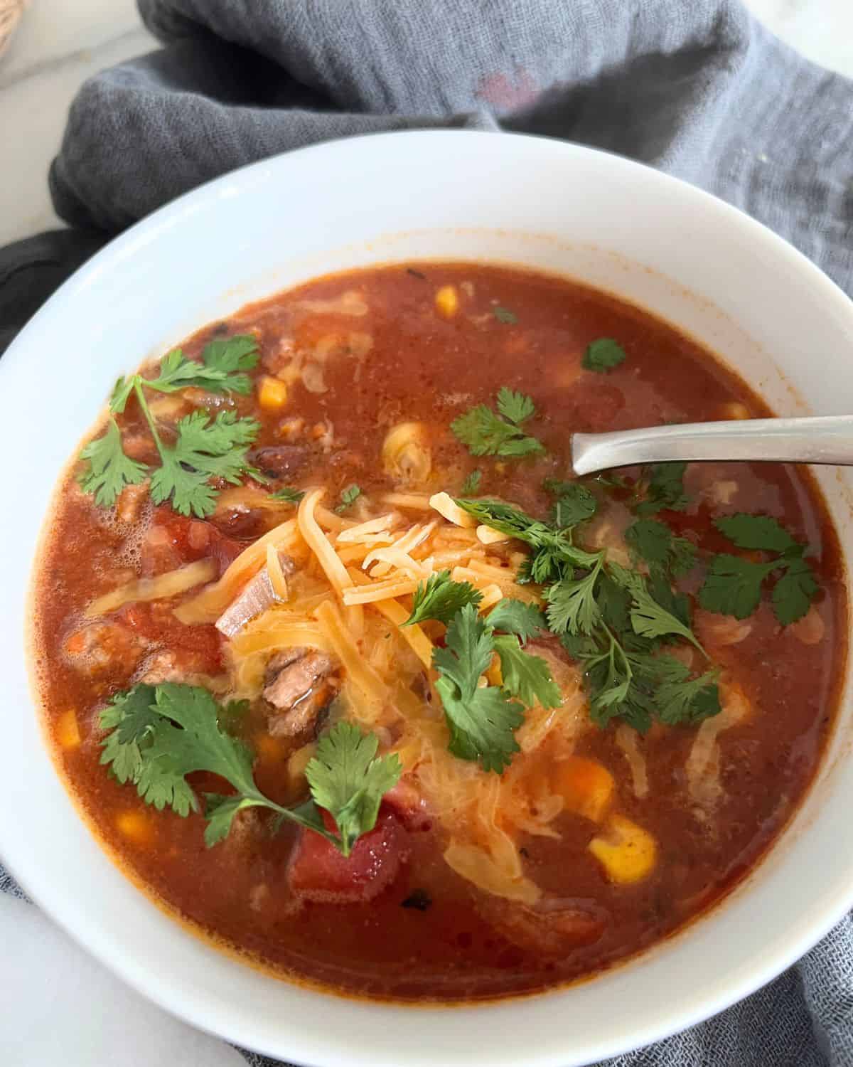 Low sodium taco soup in a white bowl with a spoon. 