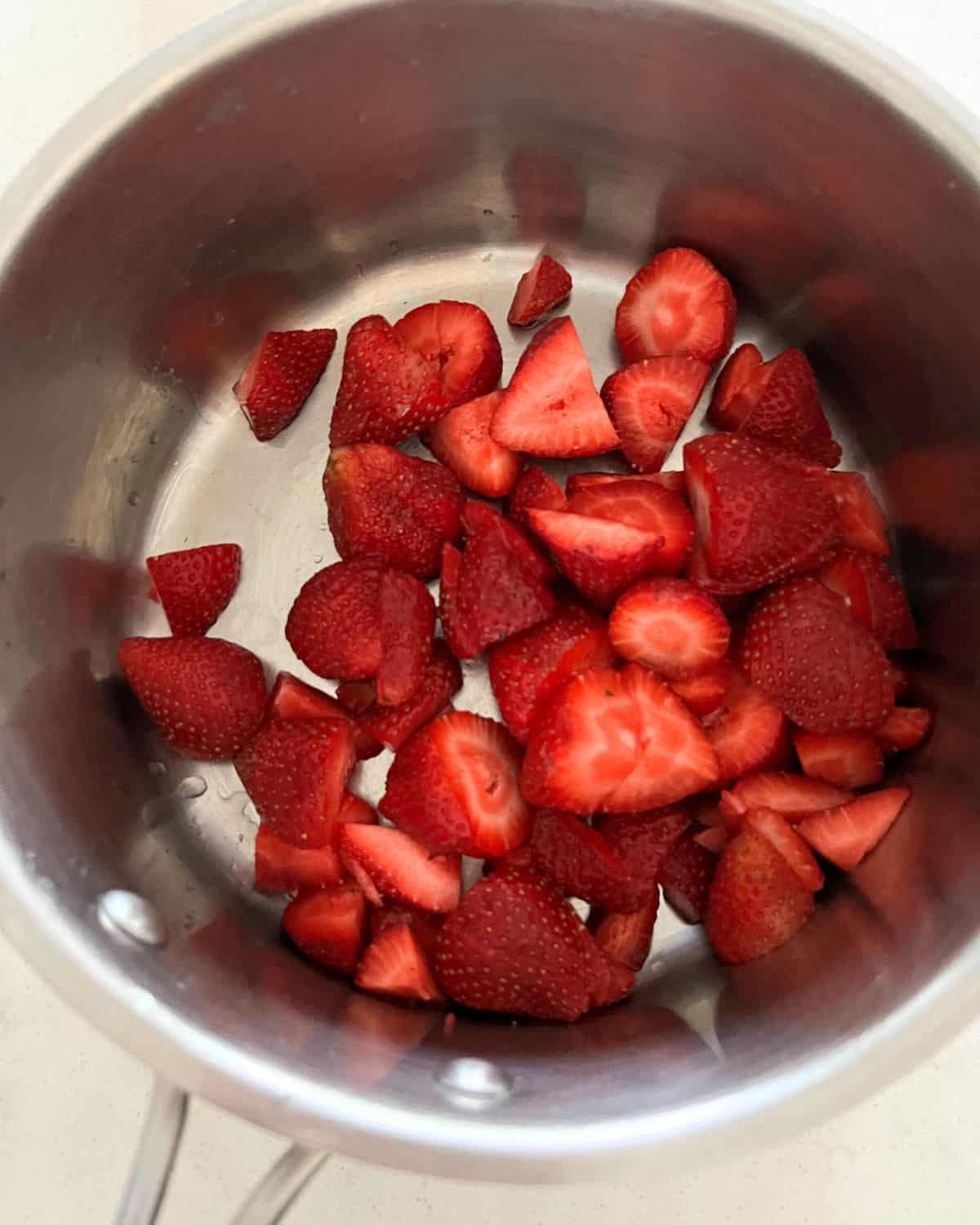 Strawberries and lemon juice in a sauce pan. 