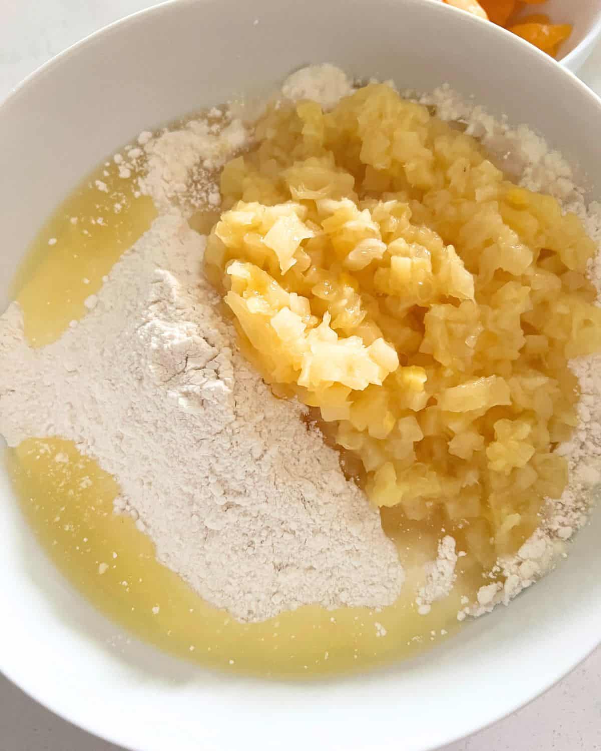 Dry cake mix and pineapple in a bowl.