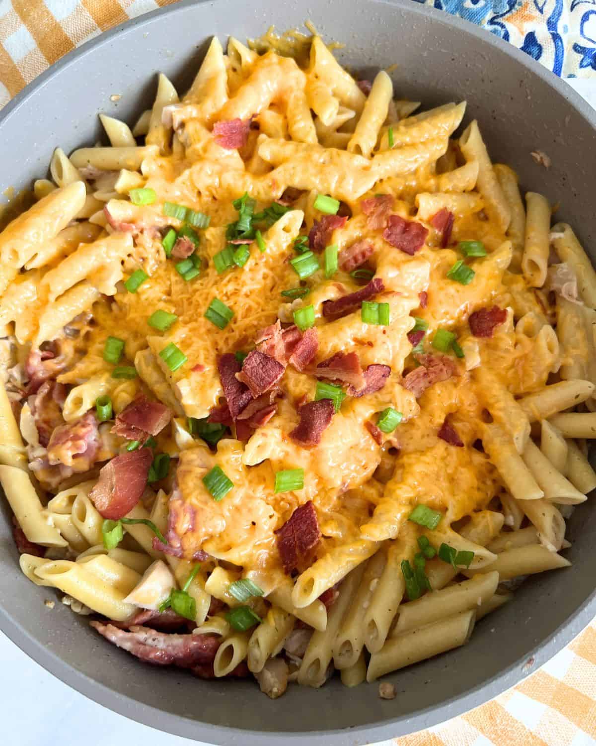 Cheddar cheese melted over pasta and topped with bacon and scallions. 