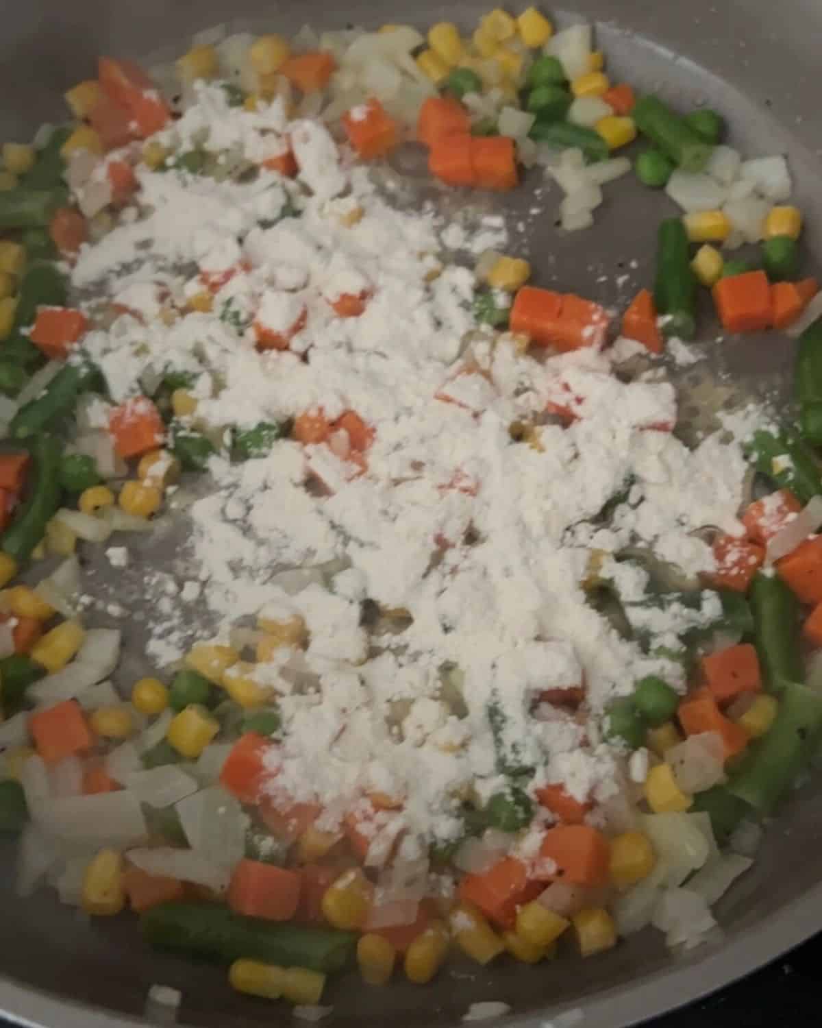 Vegetables and onions cooking in a skillet. w