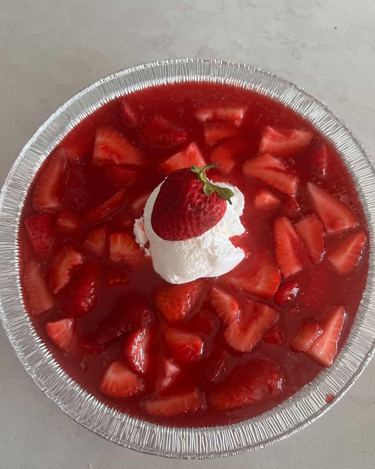 Strawberry and Jello pie topped with a fresh strawberry. 