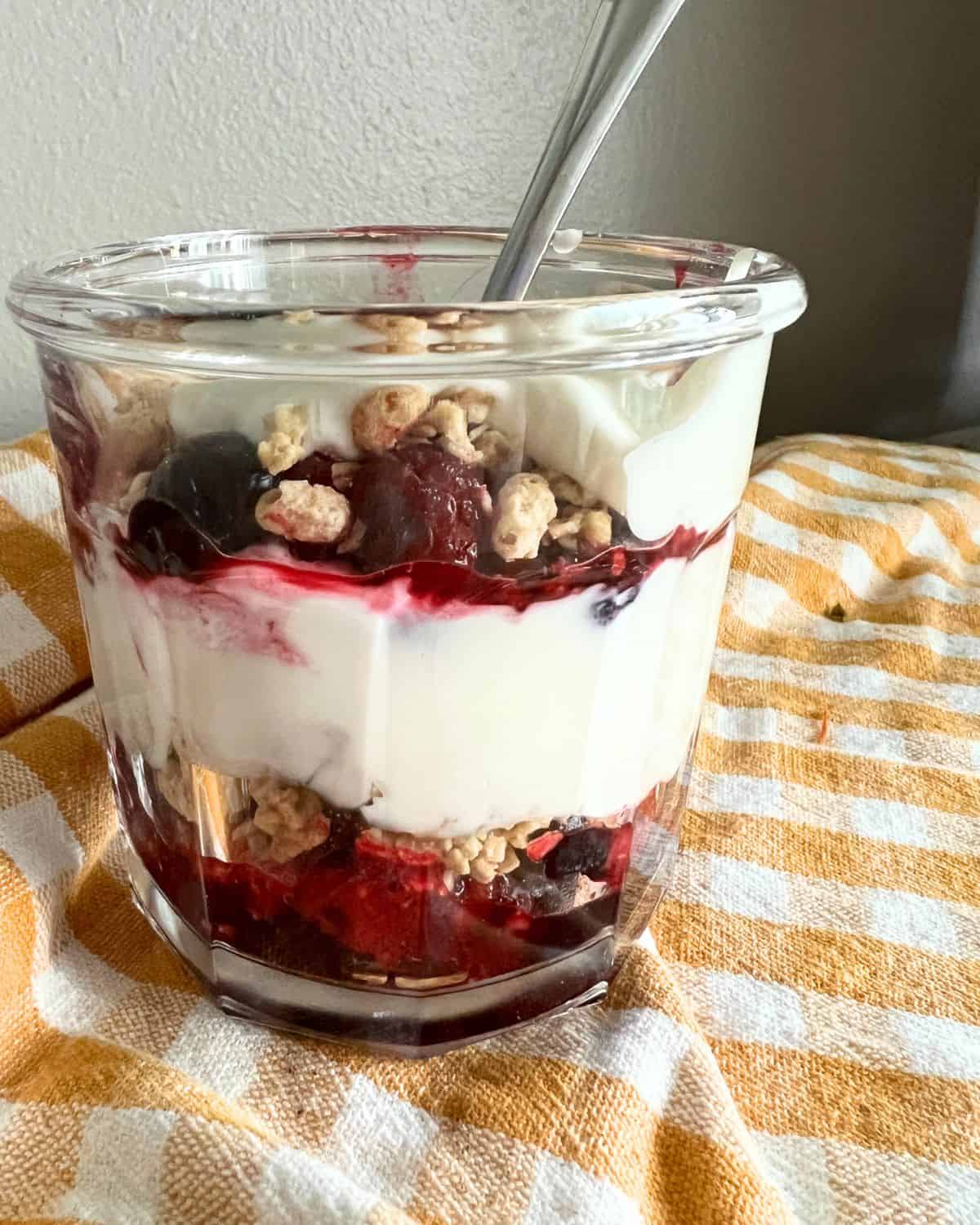Fruit, yogurt, and berries, layered in a cup. 