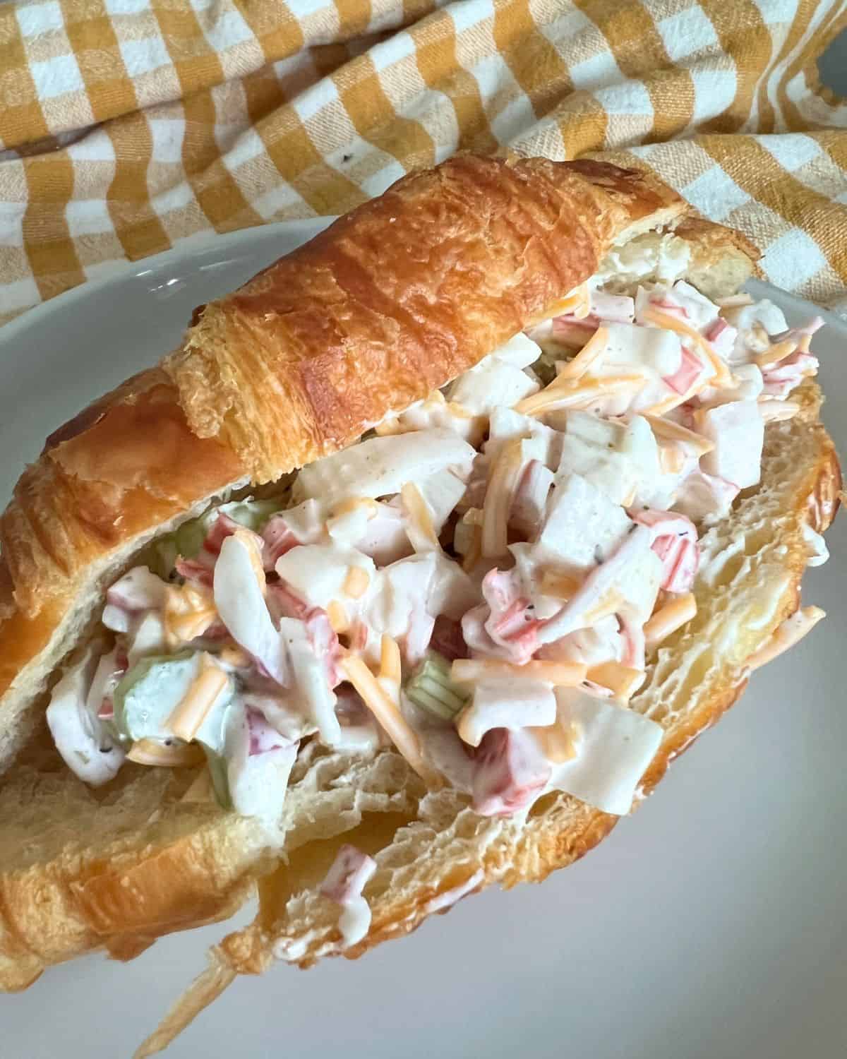 Imitation crab salad on a croissants bun. 