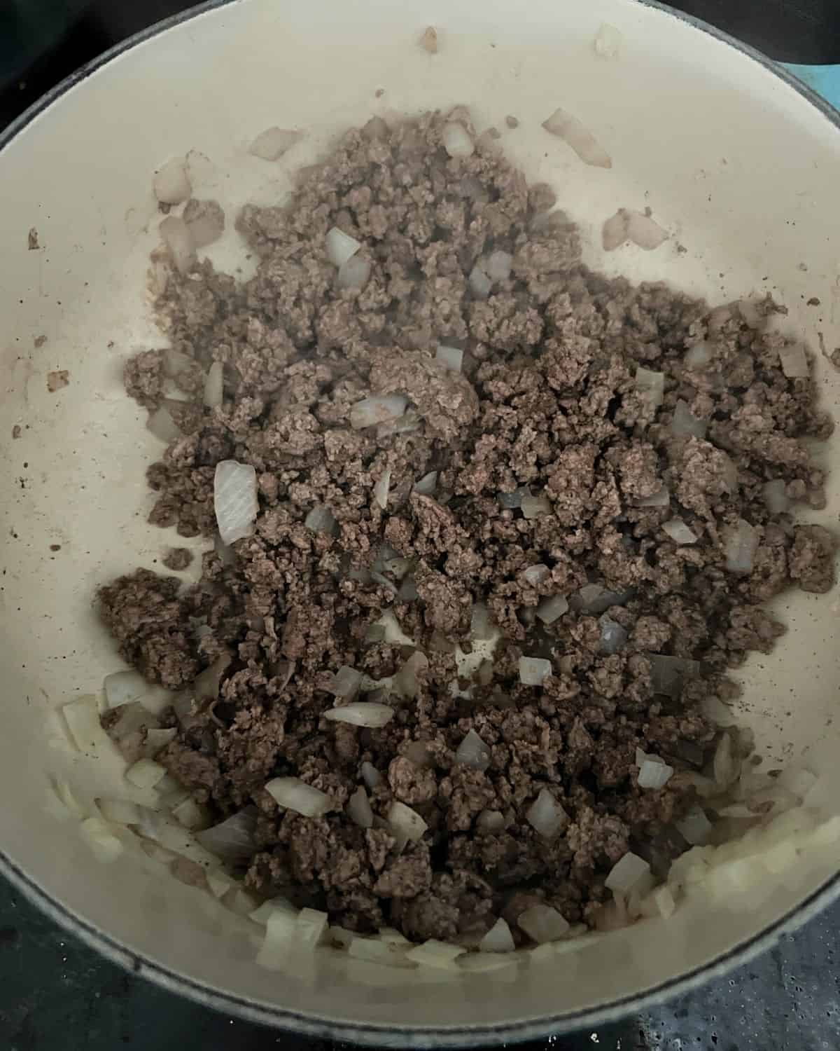 Cooked ground beef and onions in a pot. 