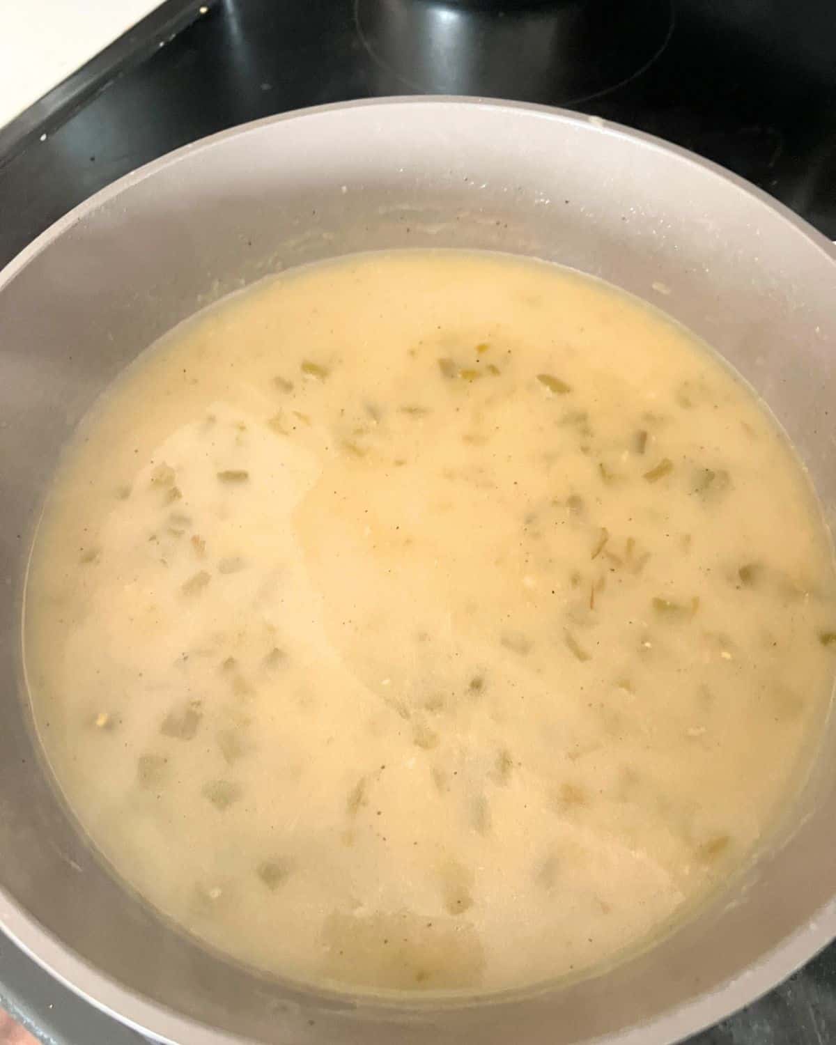 Enchilada sauce with green chilis in a pan. 