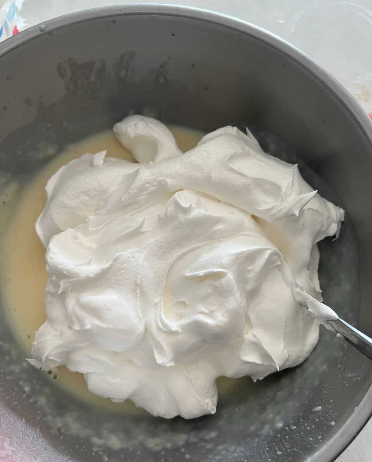 Folding cool whip into the cheese cake pudding mixture. 