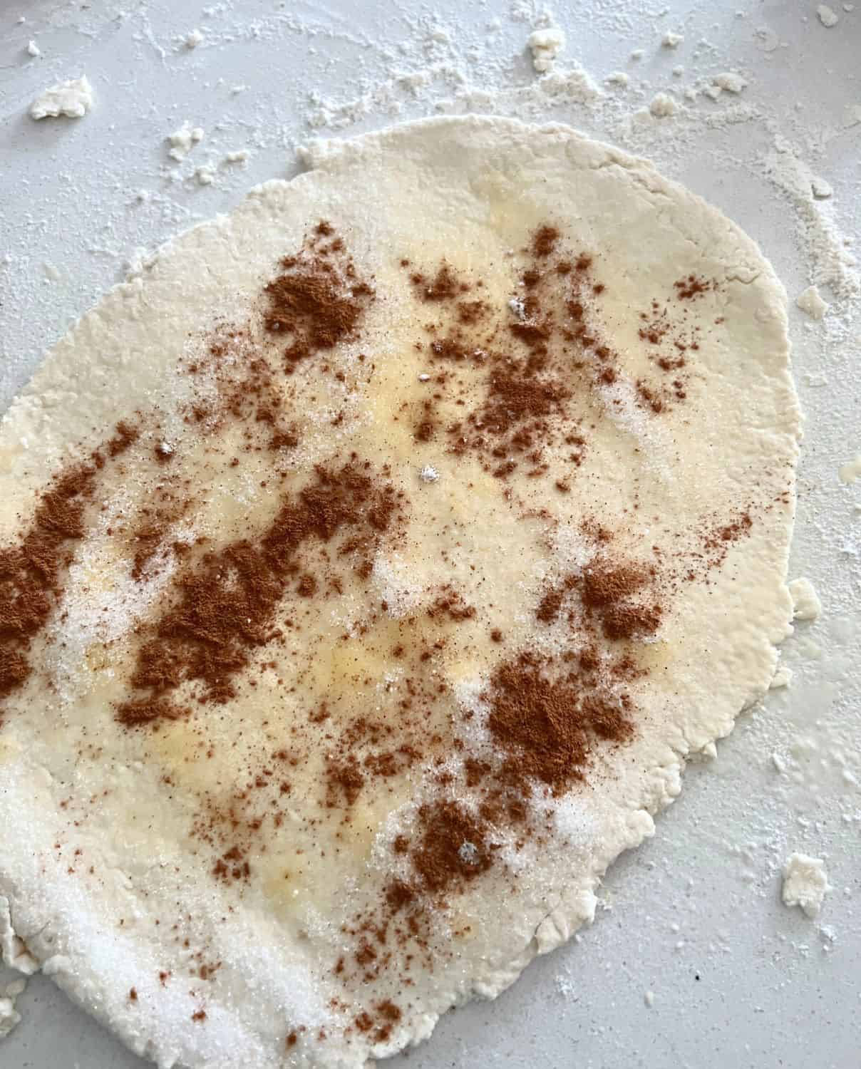 Cinnamon roll dough topped with sugar and cinnamon.