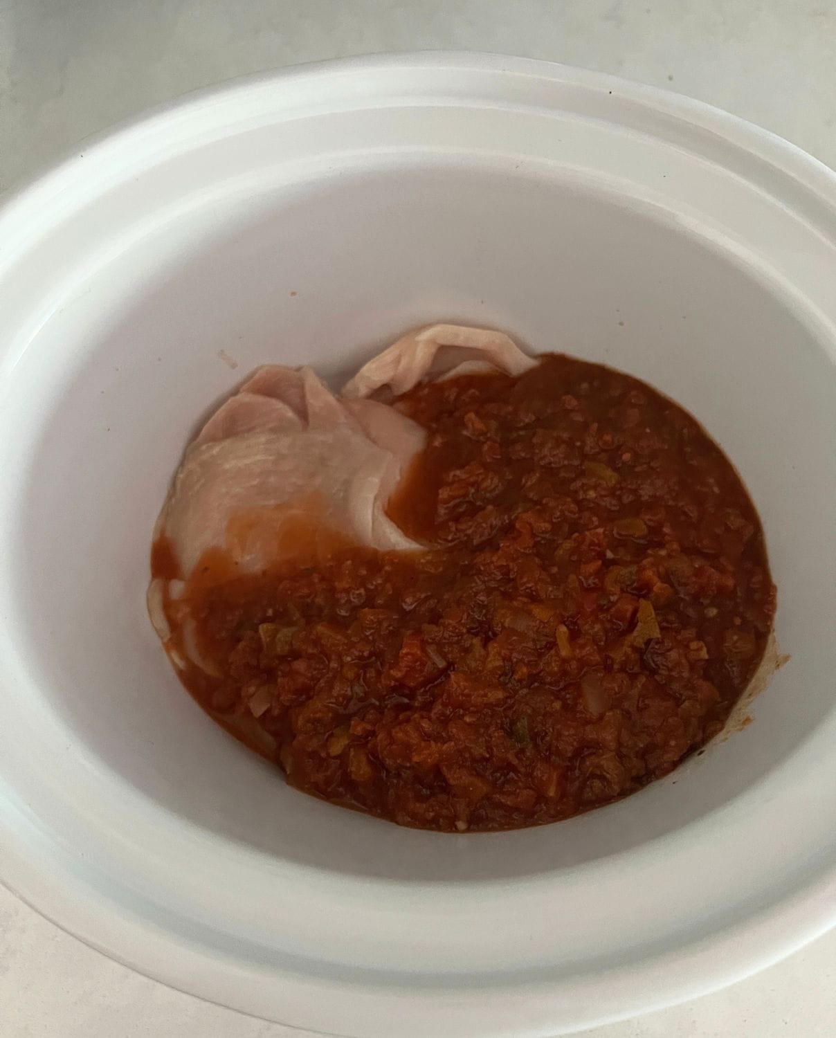 Salsa and chicken in a slow cooker. 