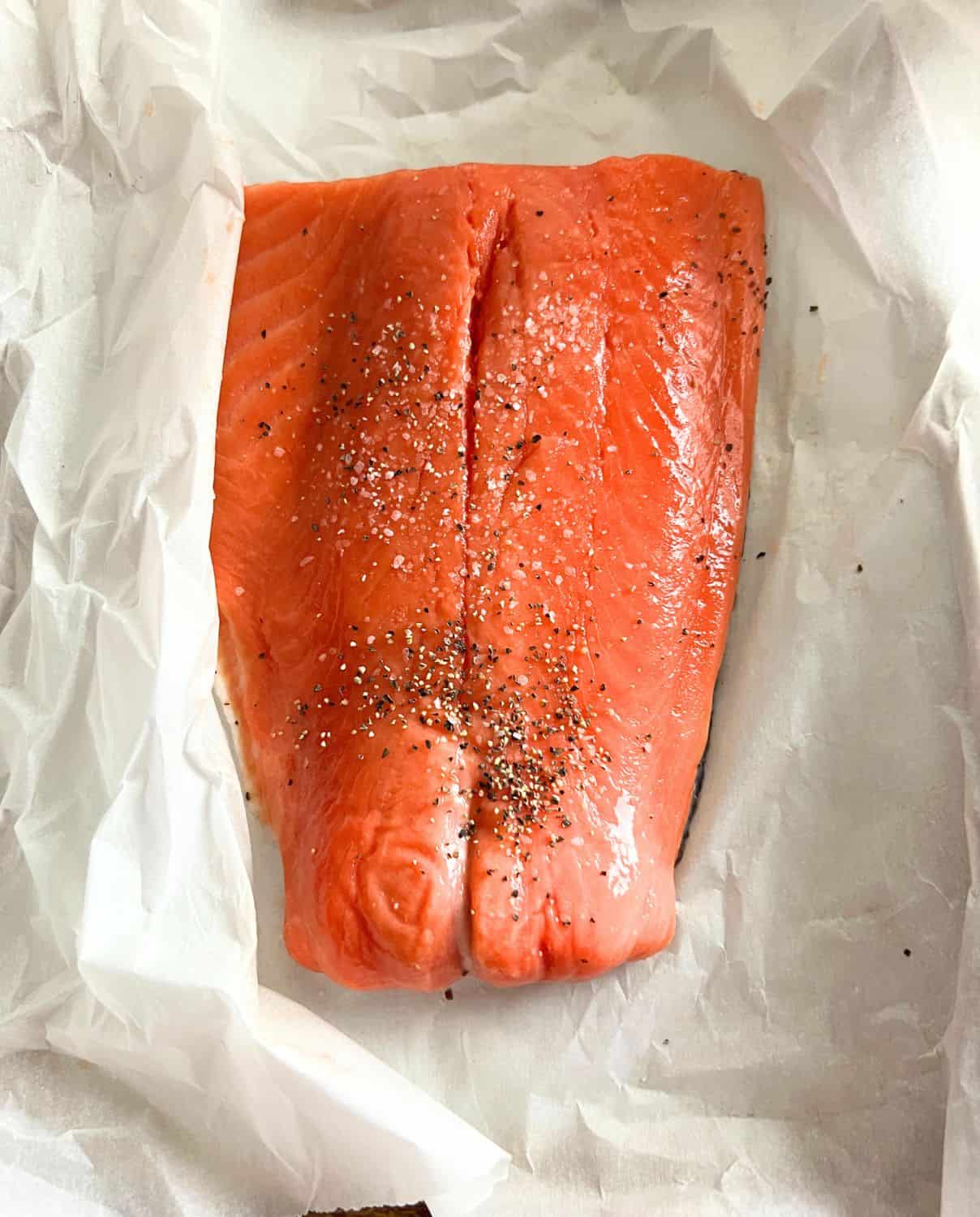 Salmon filet on top of parchment paper. 