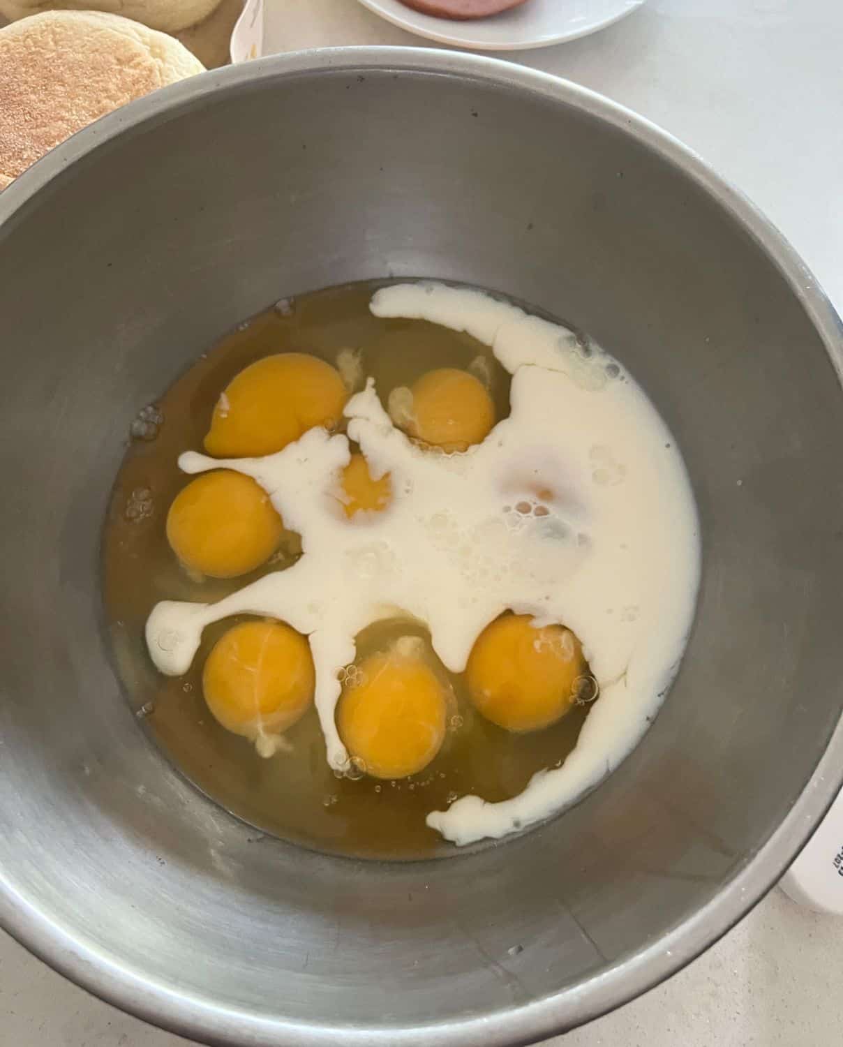 Eggs and milk together in a silver bowl. 