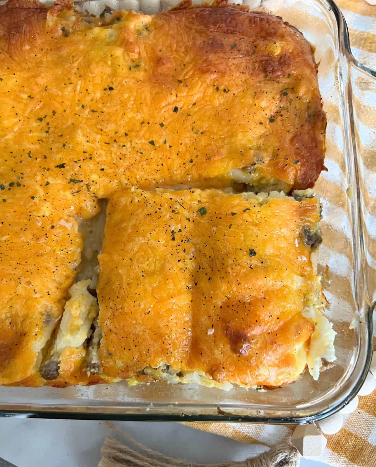 5 Ingredient sausage and egg hash brown casserole in a clear casserole dish. 