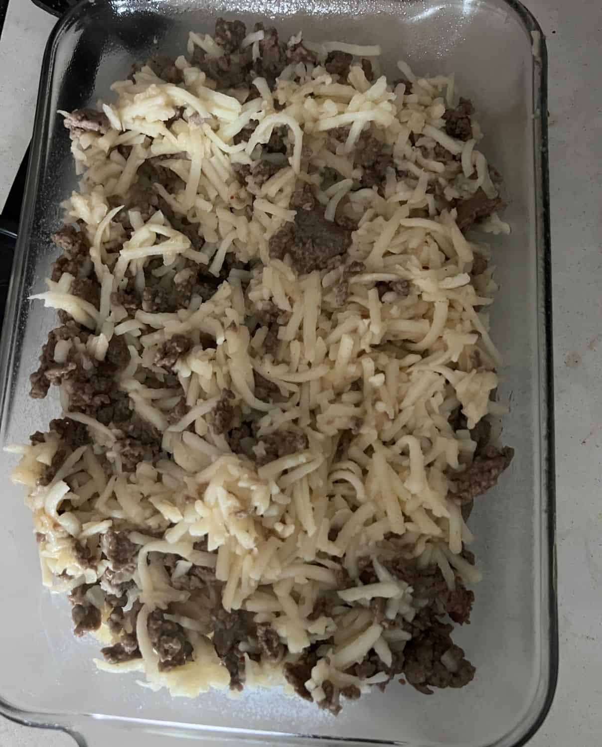 Hash browns and sausage cooked in a casserole dish. 