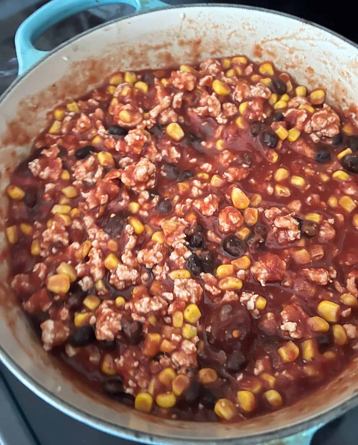 Turkey, corn, and black beans cooking in a skillet. 