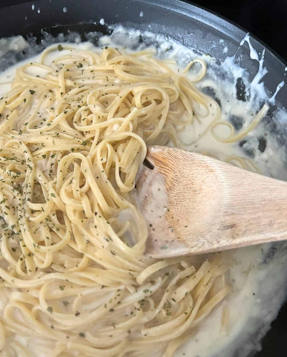 Finished alfredo sauce topped with chopped parsley. 