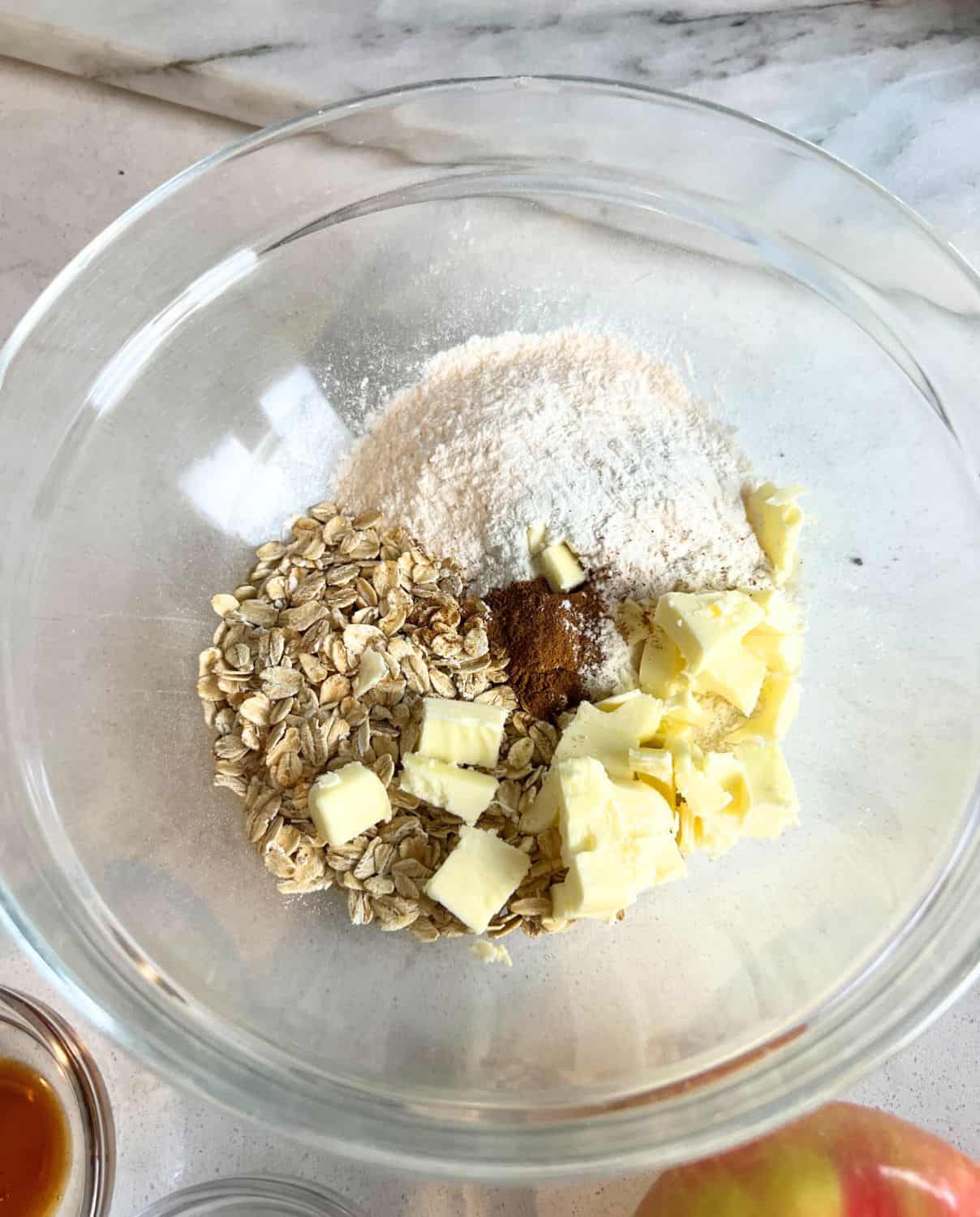 Dry ingredients in a glass bowl for apple crisp. 