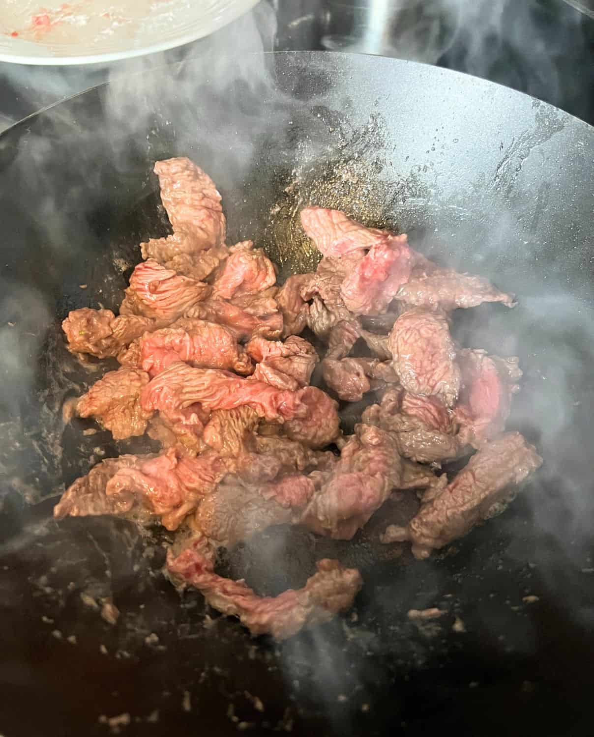 Beef cooking in a wok. 