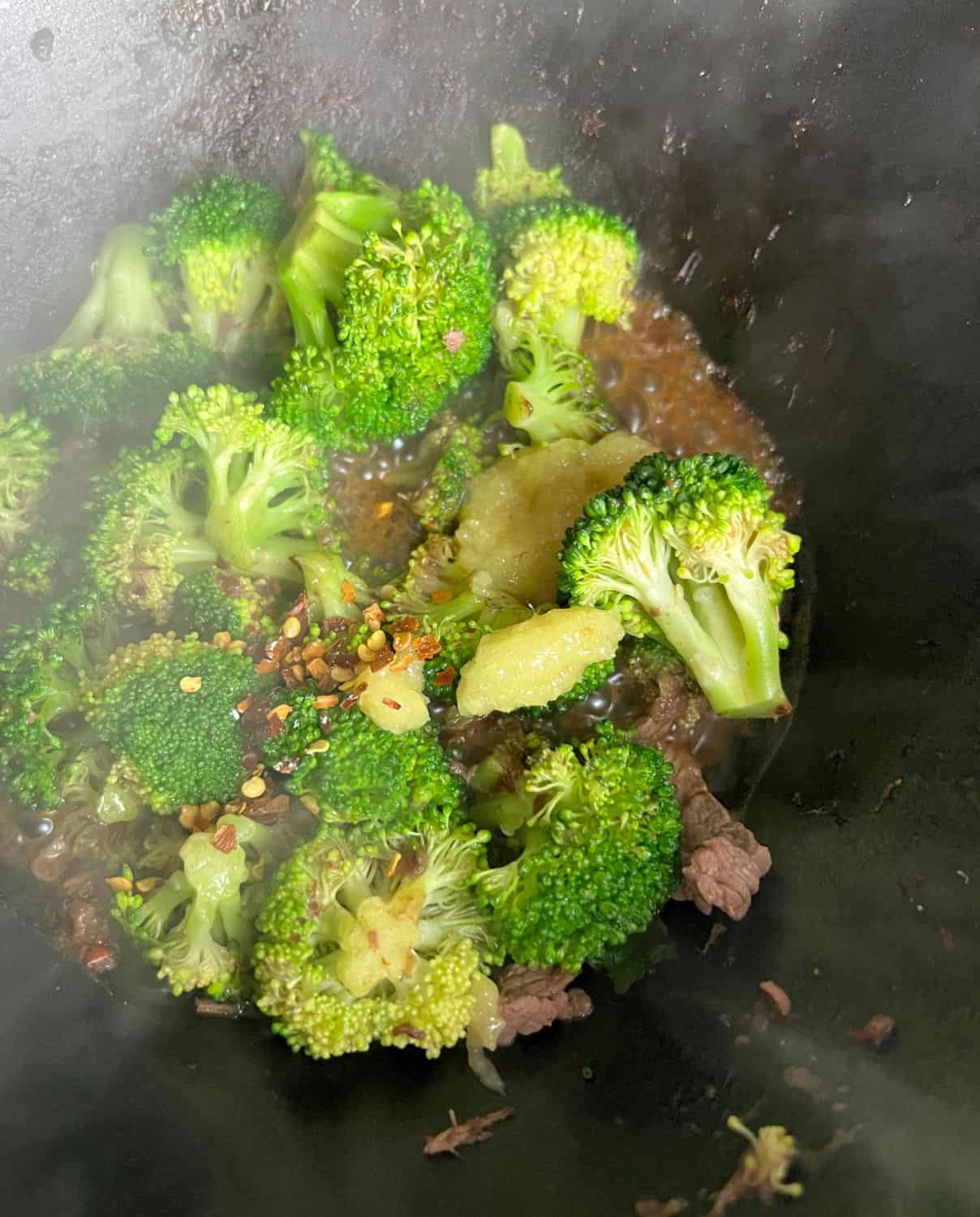 Broccoli and seasonings cooking in a skillet. 