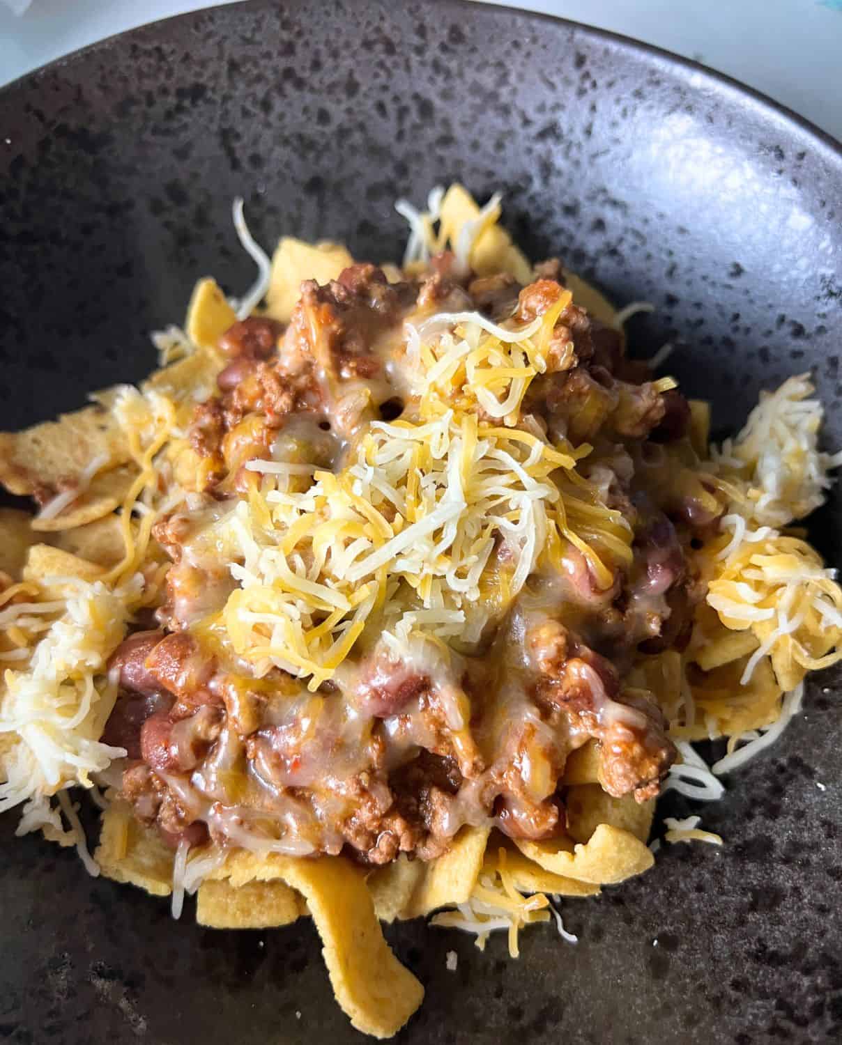 Chili on top of frito chips and cheese. 