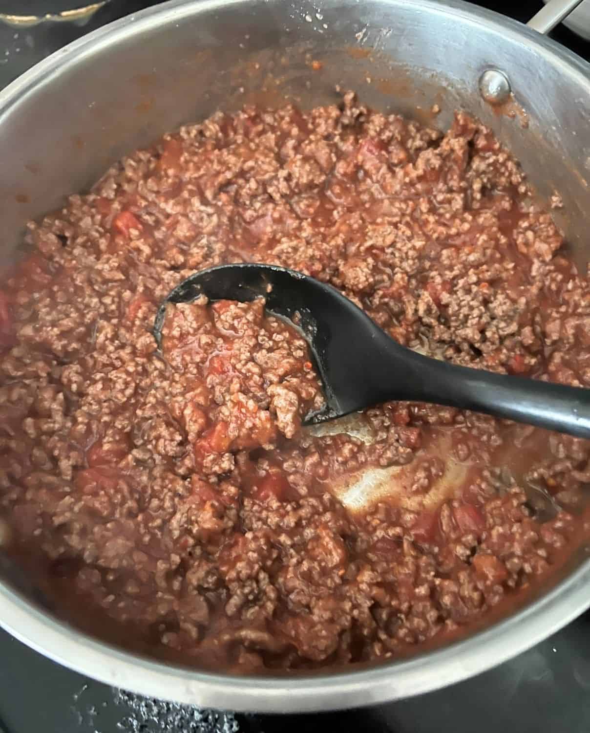 Cooked ground beef and sauce in a skillet. 