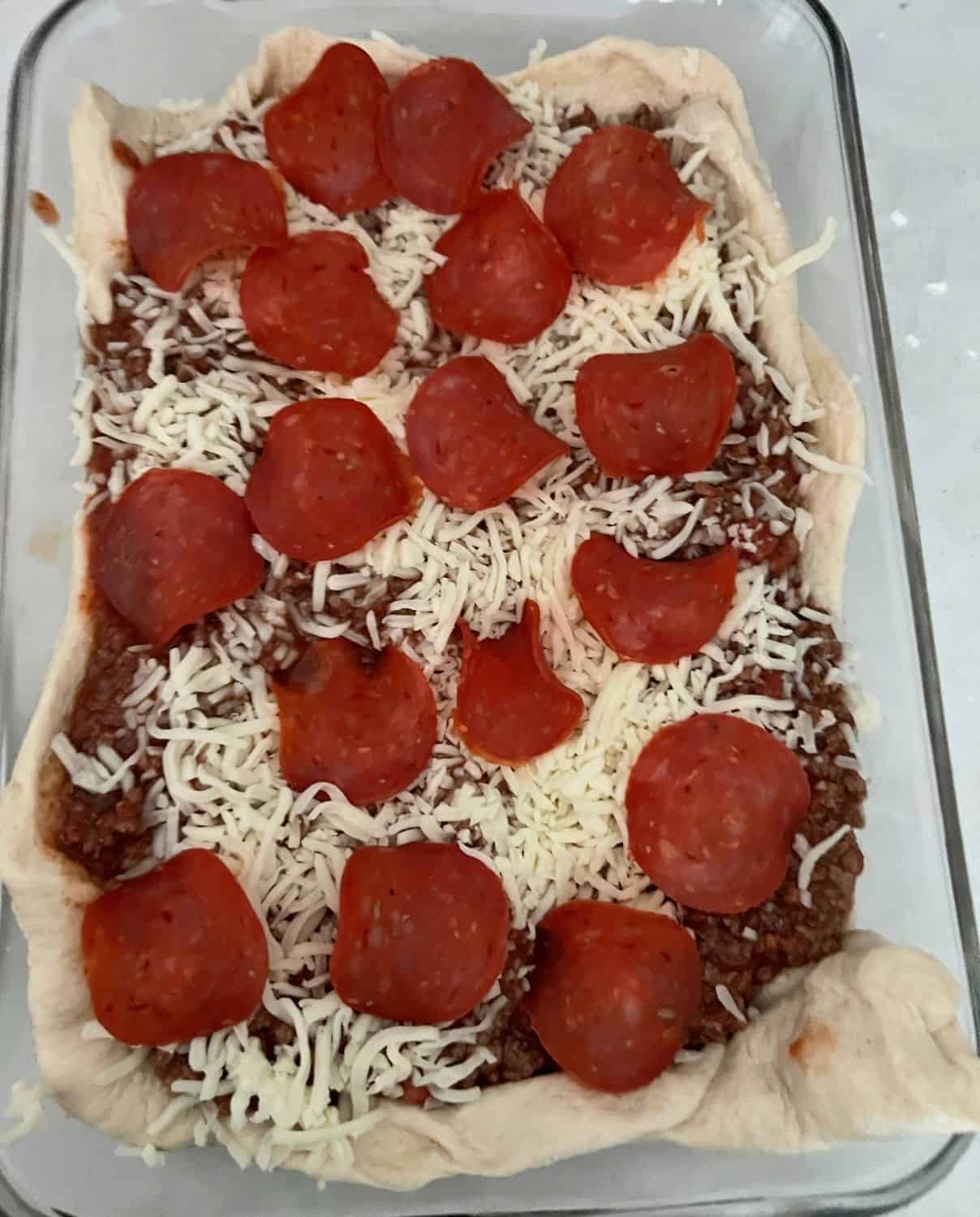Cheese and pepperoni on top of pizza casserole. 