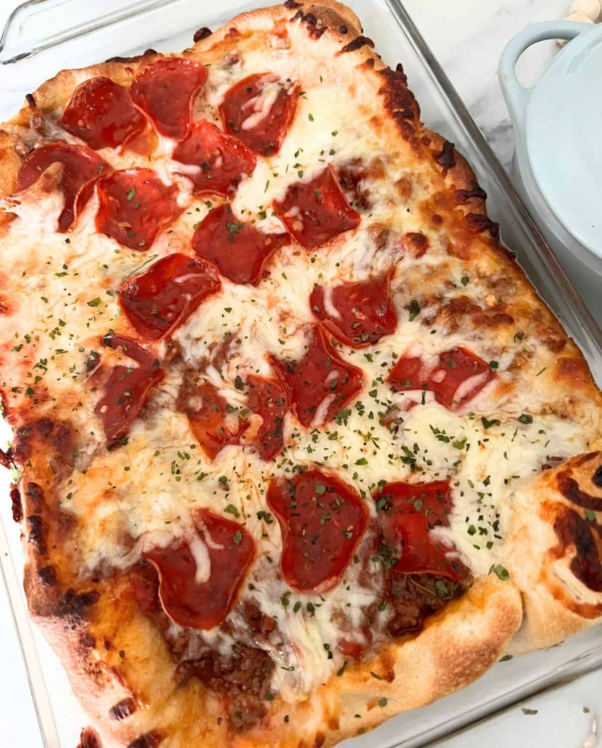 Finished deep dish pizza casserole in a clear casserole dish. 