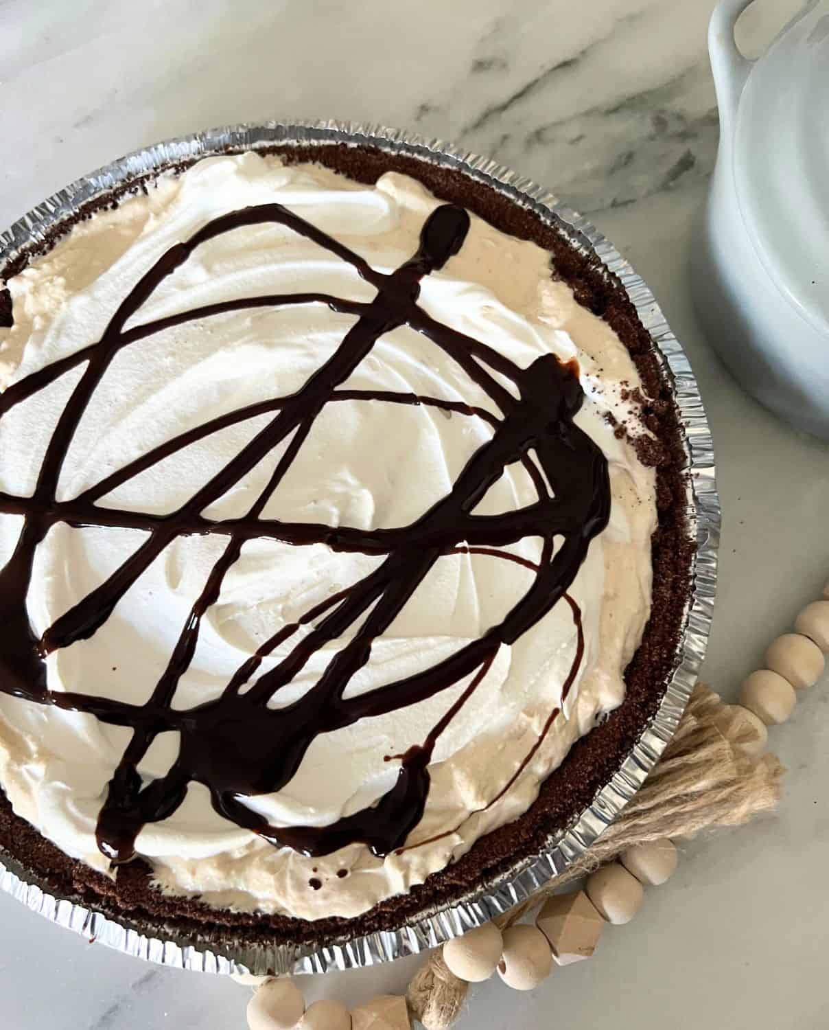 Chocolate peanut butter pie drizzled with chocolate in a chocolate pie crust. 