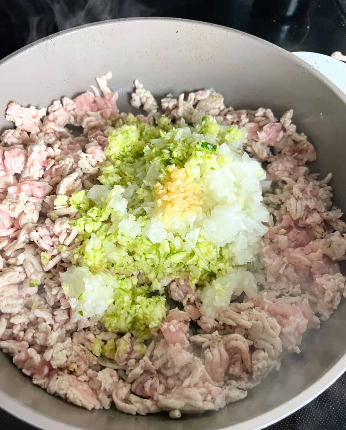 Ground turkey and vegetables cooking in a skillet. 