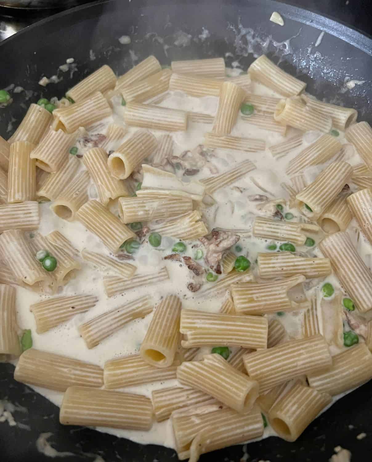 Parmasan Cheese and heavy cream with noodles in a pot. 