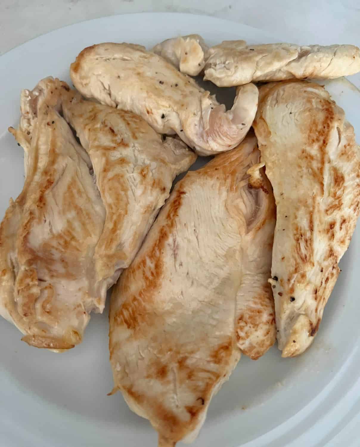Cooked chicken transfered to a plate. 