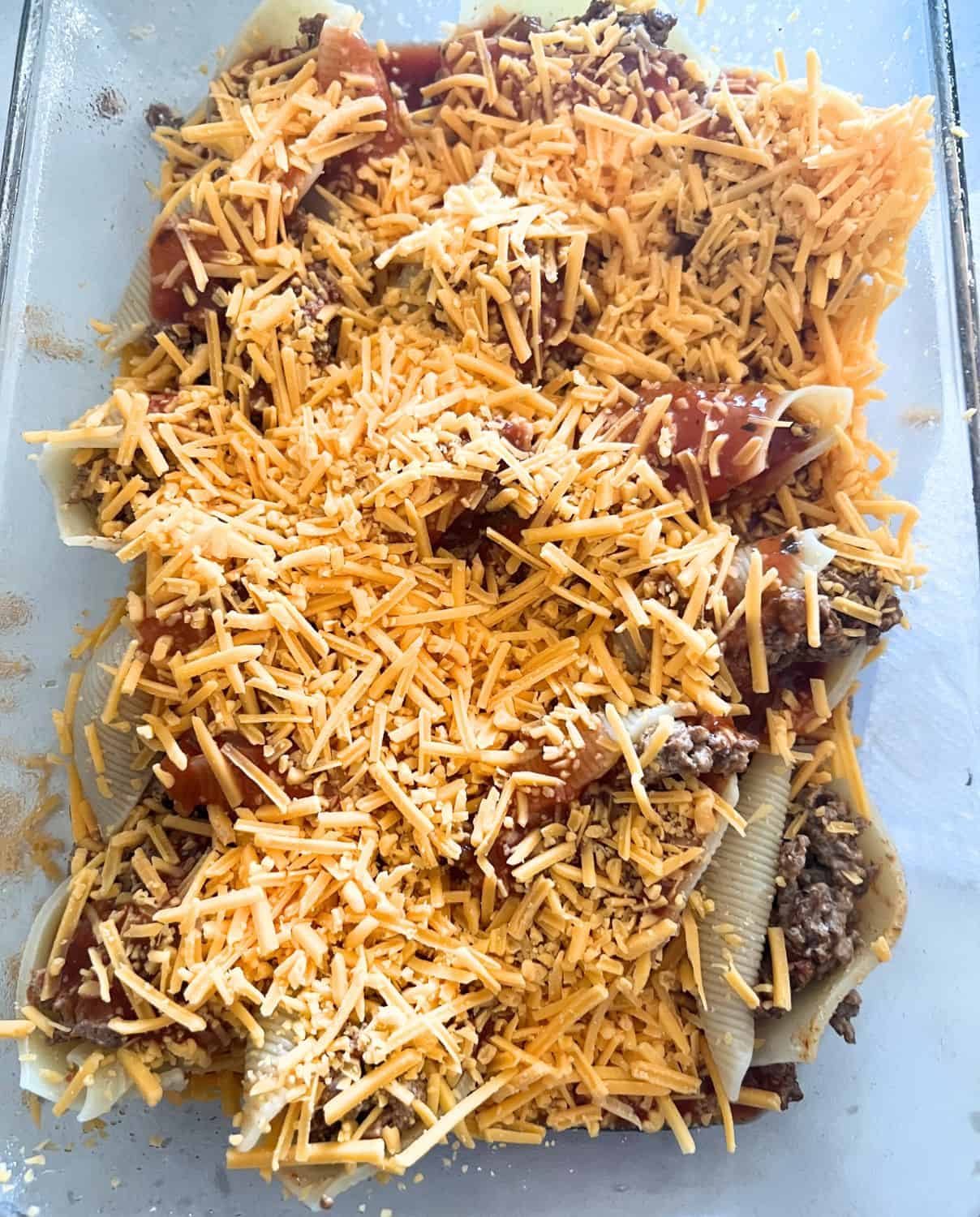 Mexican stuffed shells topped with cheese.