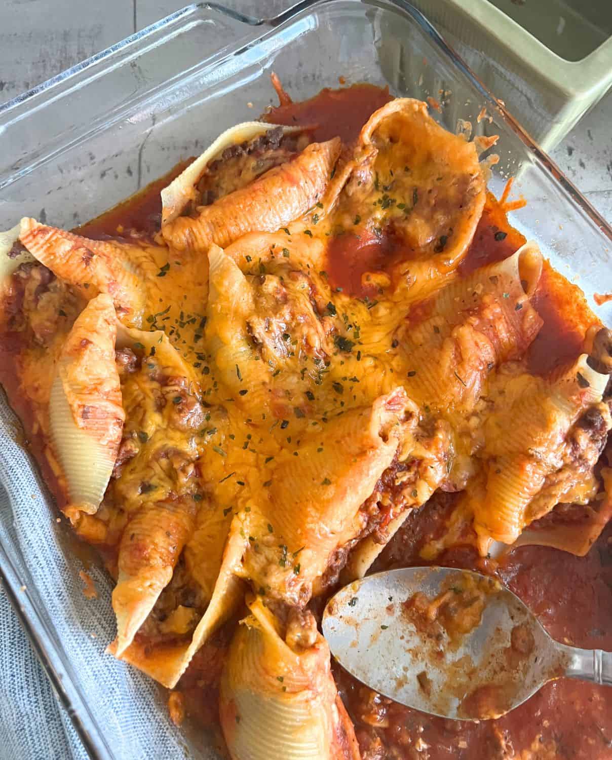 Mexican stuffed shells topped with cheese and fresh parsley.