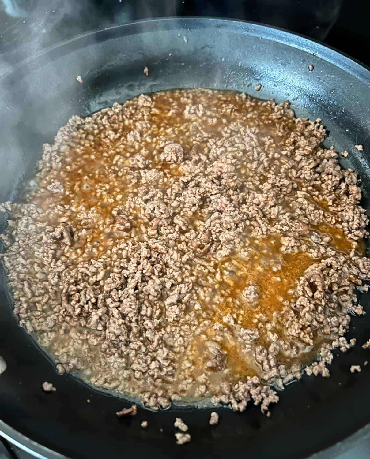 Cooked ground beef in a skillet. 