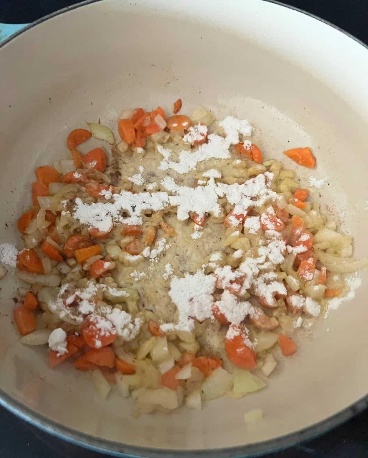 Onions, carrots, and flour cooking together in a pot. 
