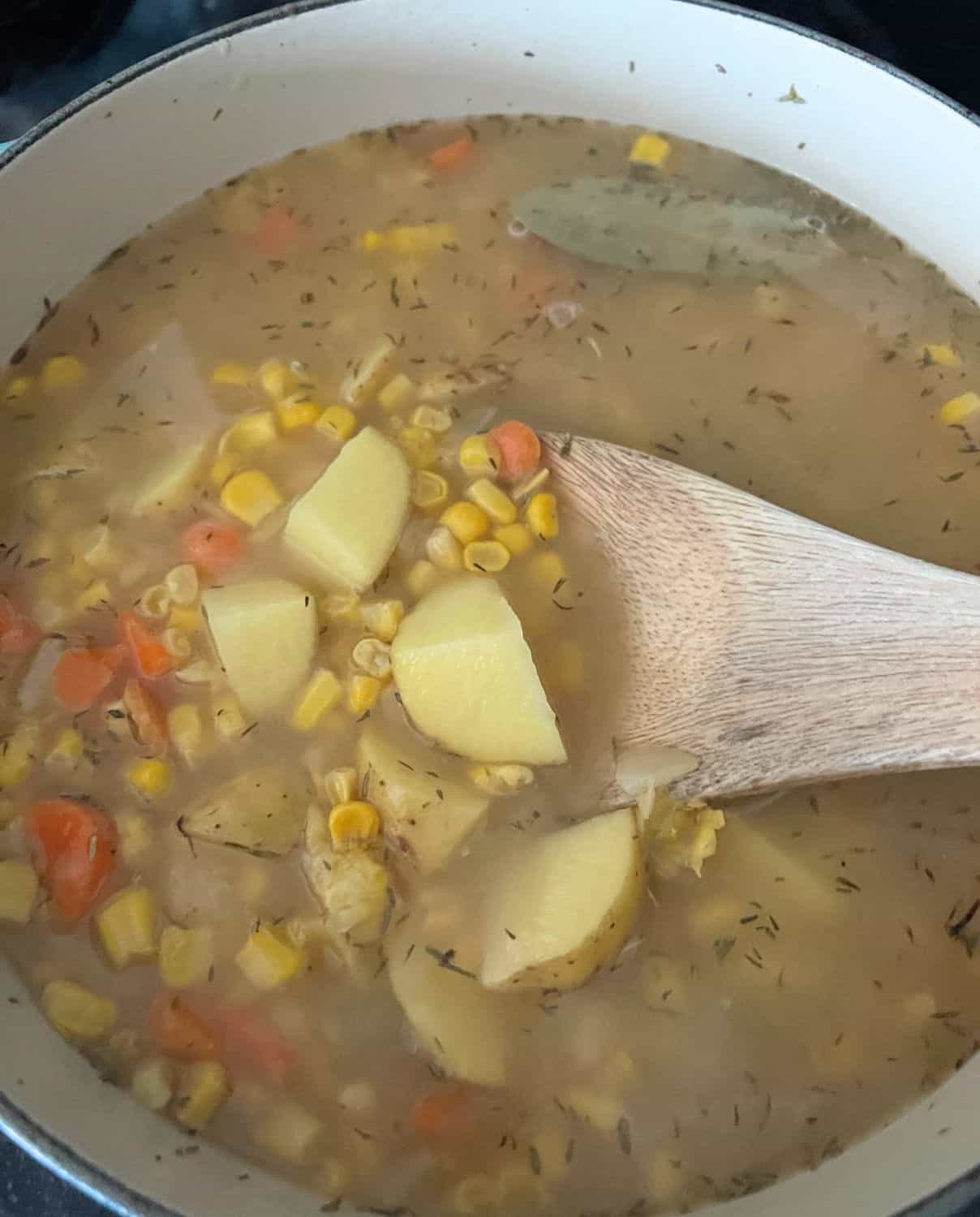 Potatoes and corn cooking together in a pot. 