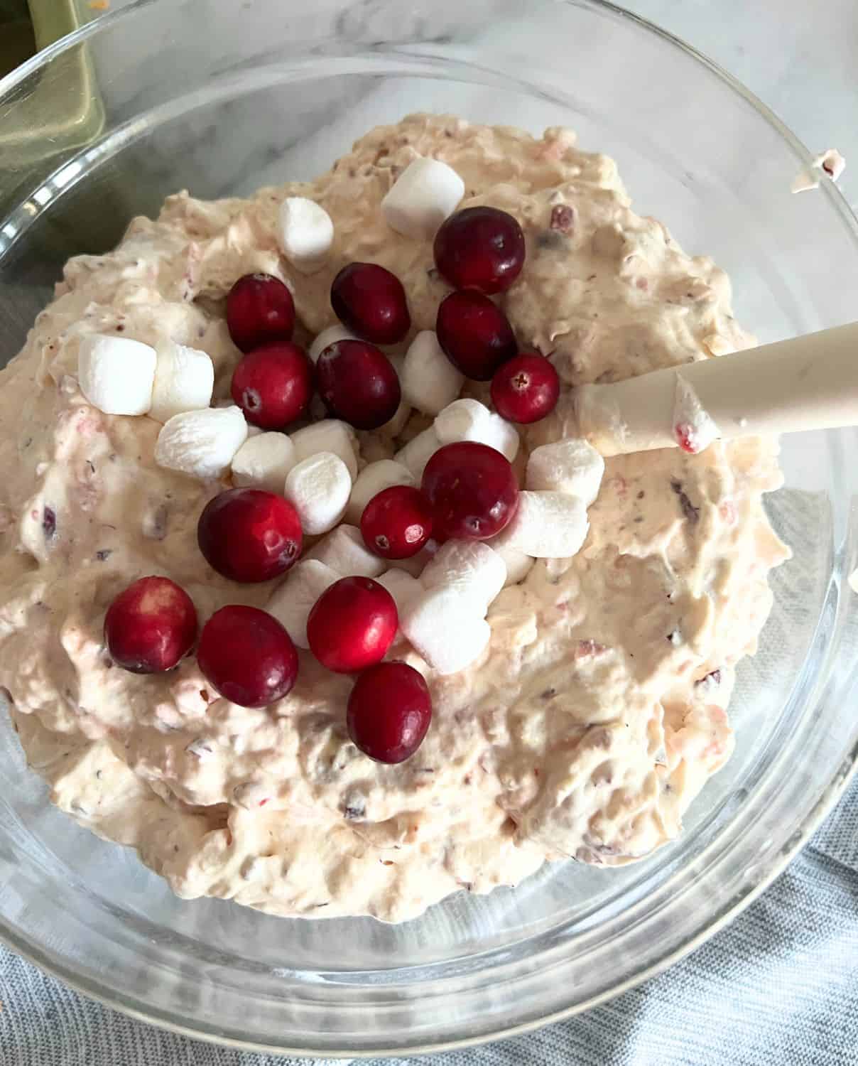 Completed cranberry fluff salad topped with marshmallows and fresh cranberries. 