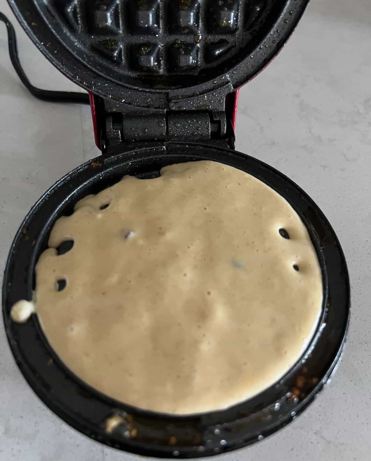 Waffle batter mix in a waffle iron. 