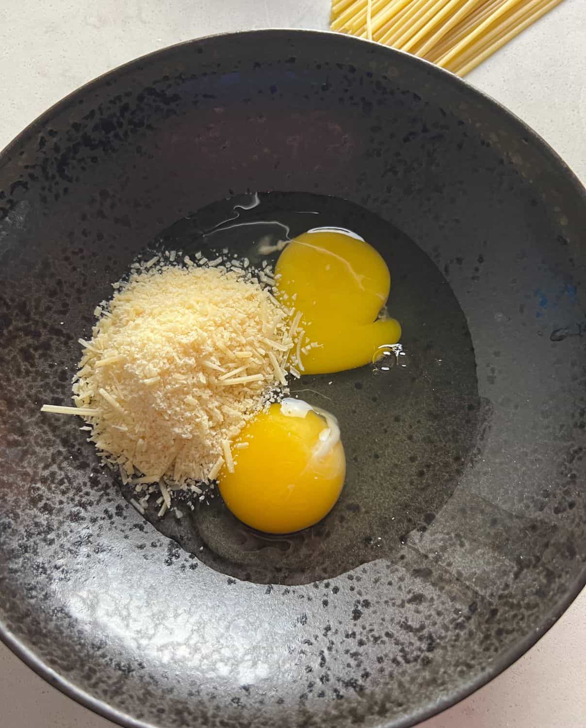 Eggs and cheese in a black bowl. 