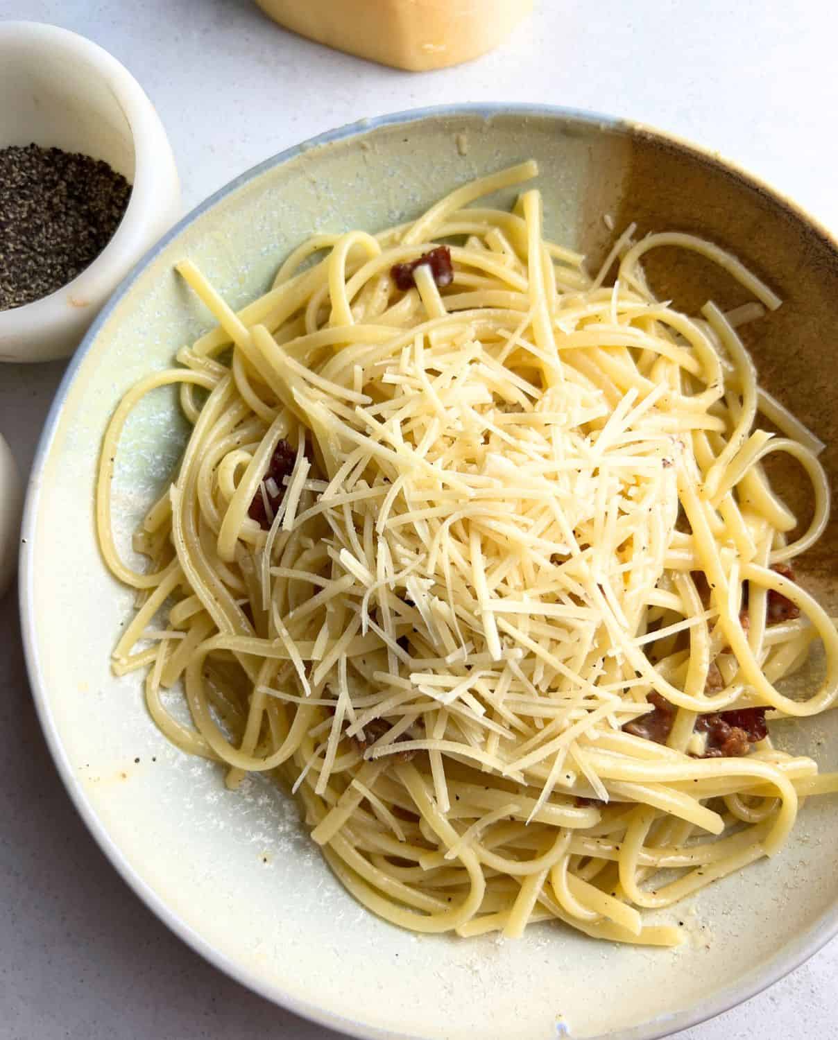 Finished Spaghetti Carbonara in a white and blue dish. 