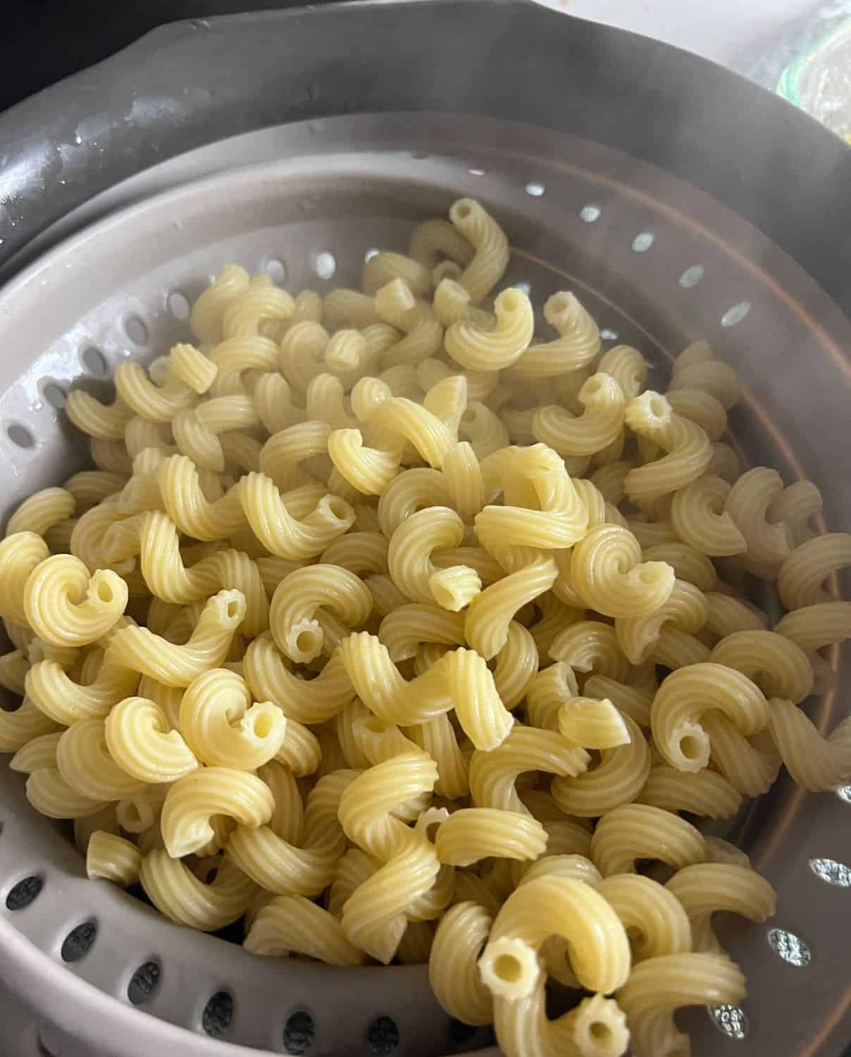 Boiled cavatappi pasta in strainer. 