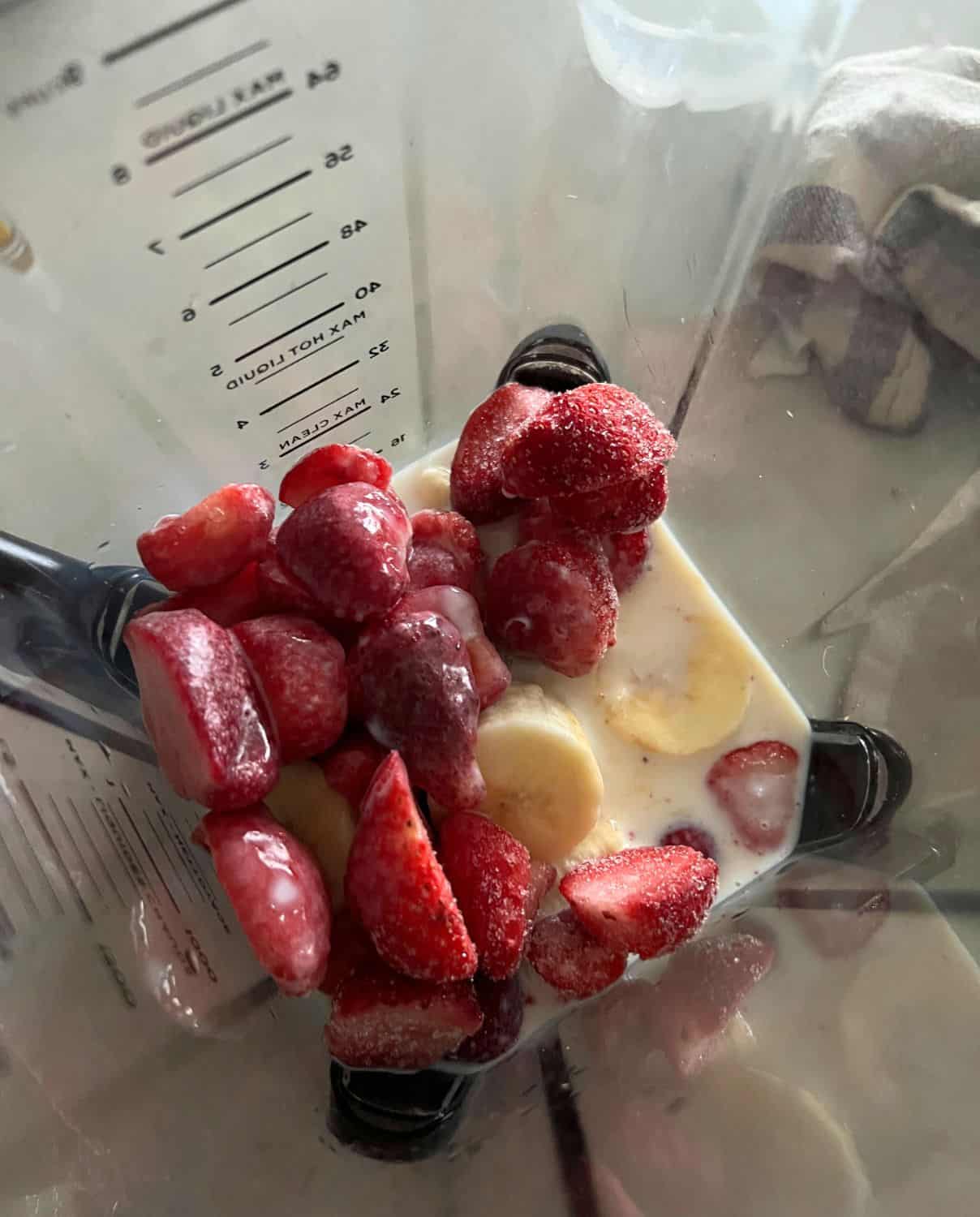 Ingredients for strawberry banana sorbet in a blender. 