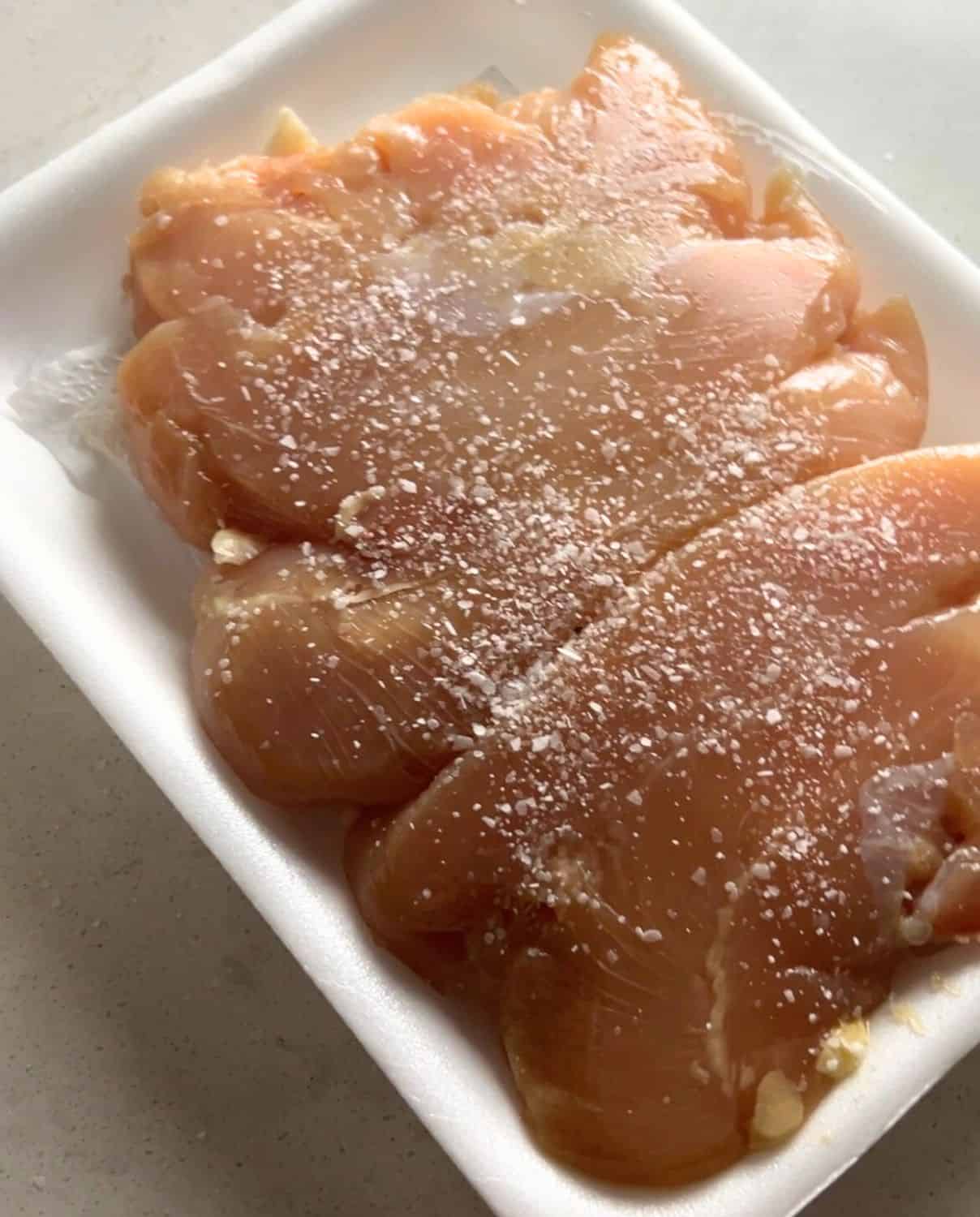 Seasoned chicken breasts with salt. 