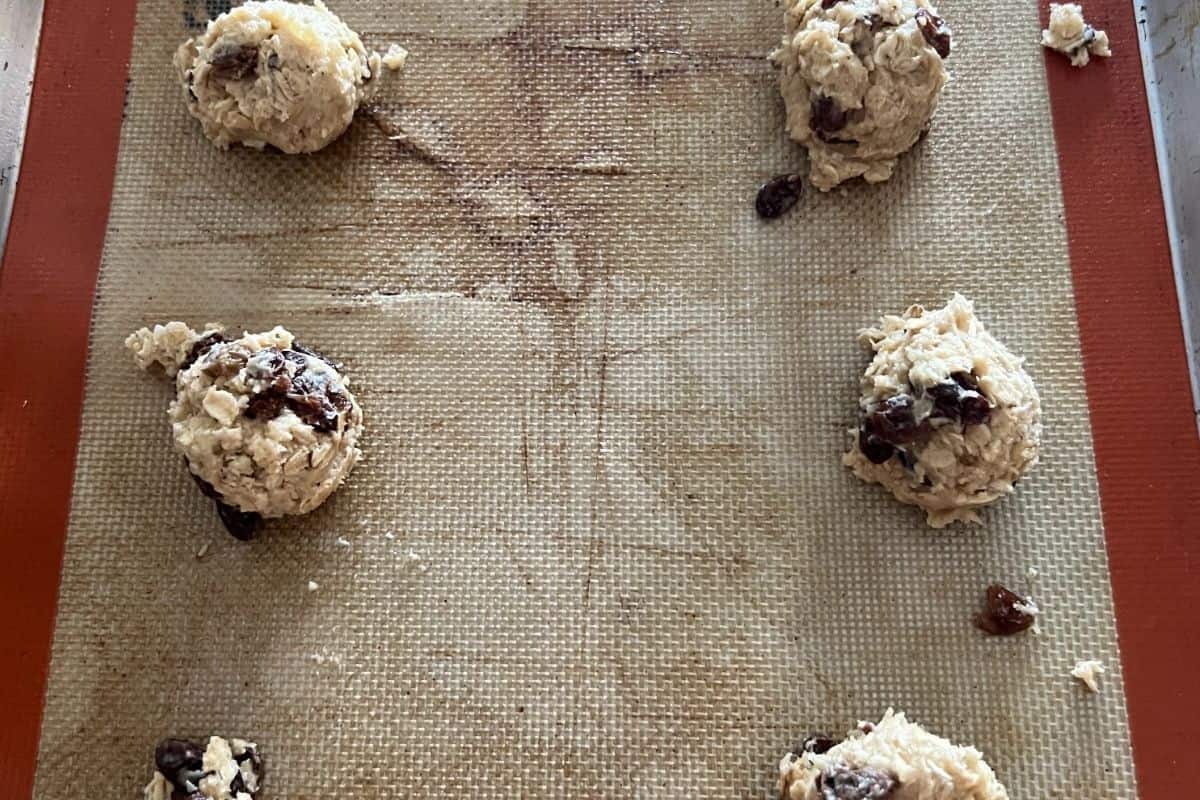 Spooned cookies on a baking sheet ready for the oven. 