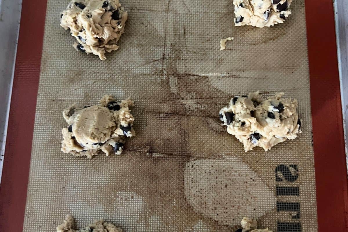 Cookies scooped out on a baking sheet with silipat lining. 