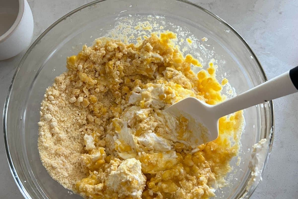 Corn, corn muffin mix, sour cream, and butter mixed together in a bowl. 