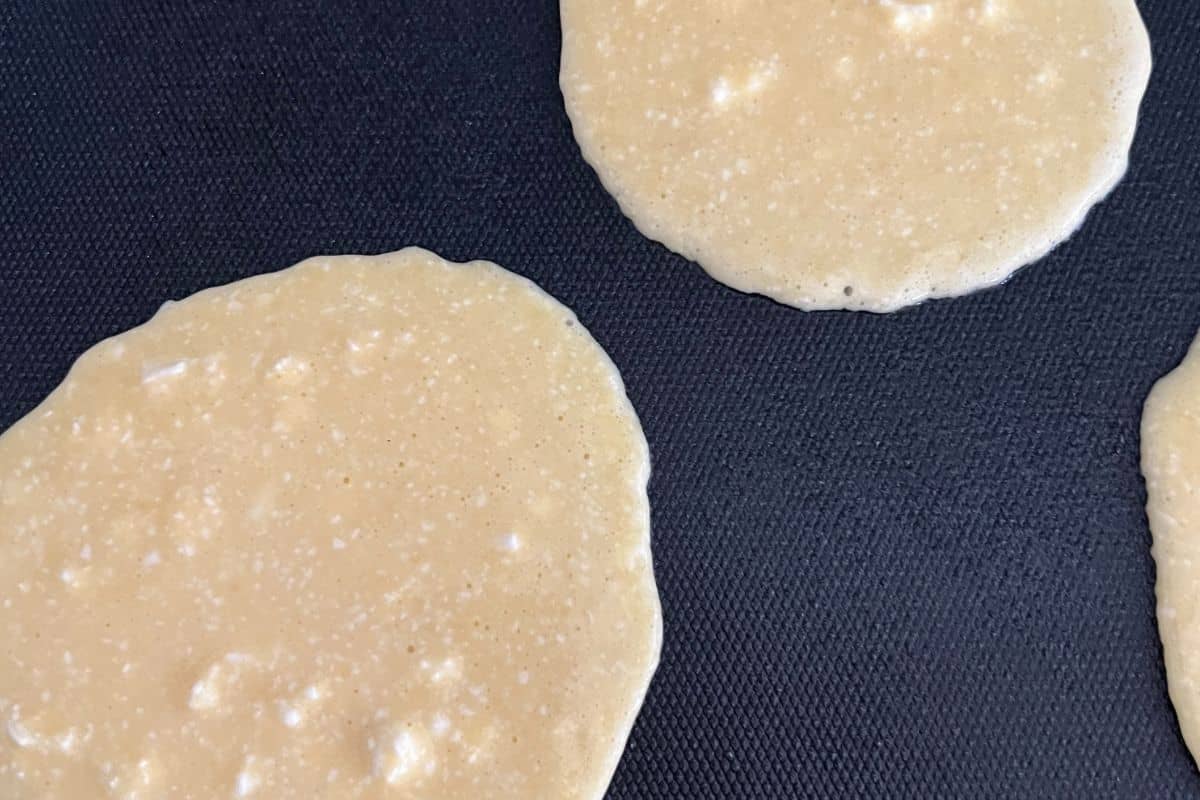 Cottage cheese pancakes cooking on a griddle. 