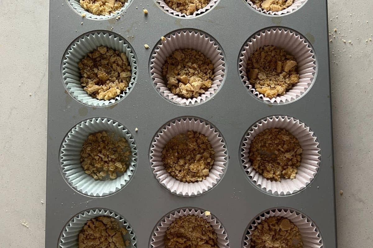 Graham cracker crumbs in some muffin cups. 