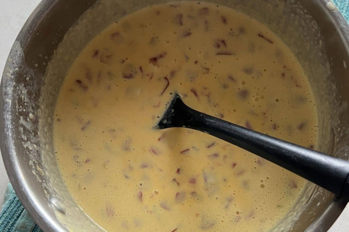Cheese sauce cooking in a sauce pan. 