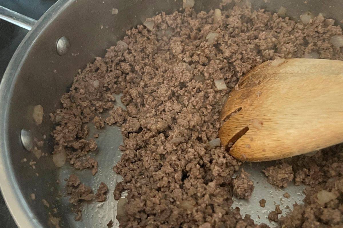 Ground beef and onions cooking in a skillet. 