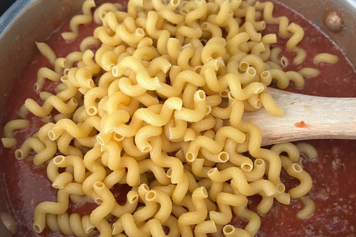Pasta noodles mixed in red beef sauce.